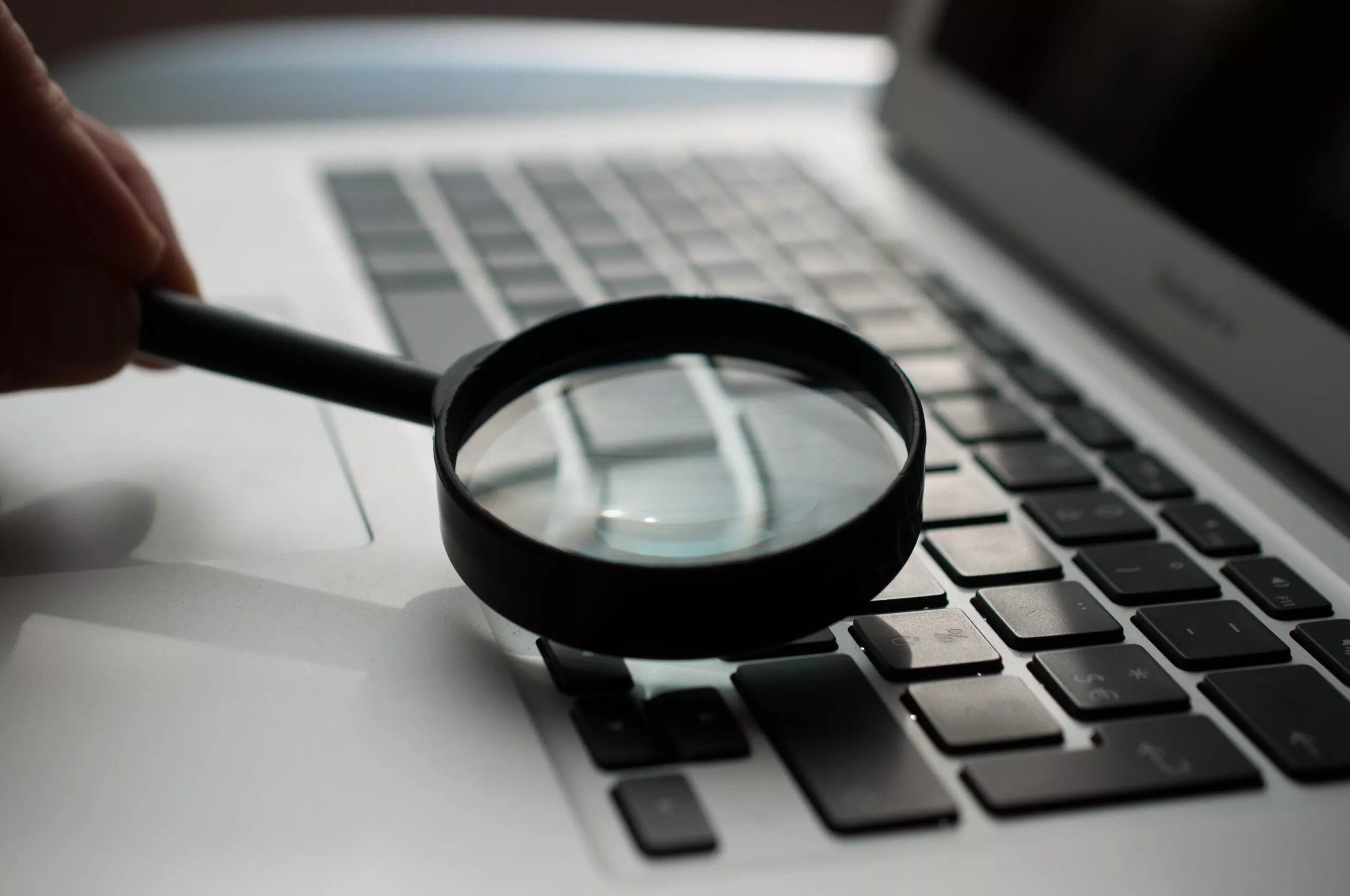 Image d’une personne regardant à la loupe son clavier Image de Agence Olloweb sur Unsplash