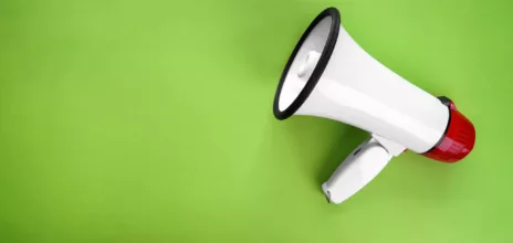 Megaphone on color background
