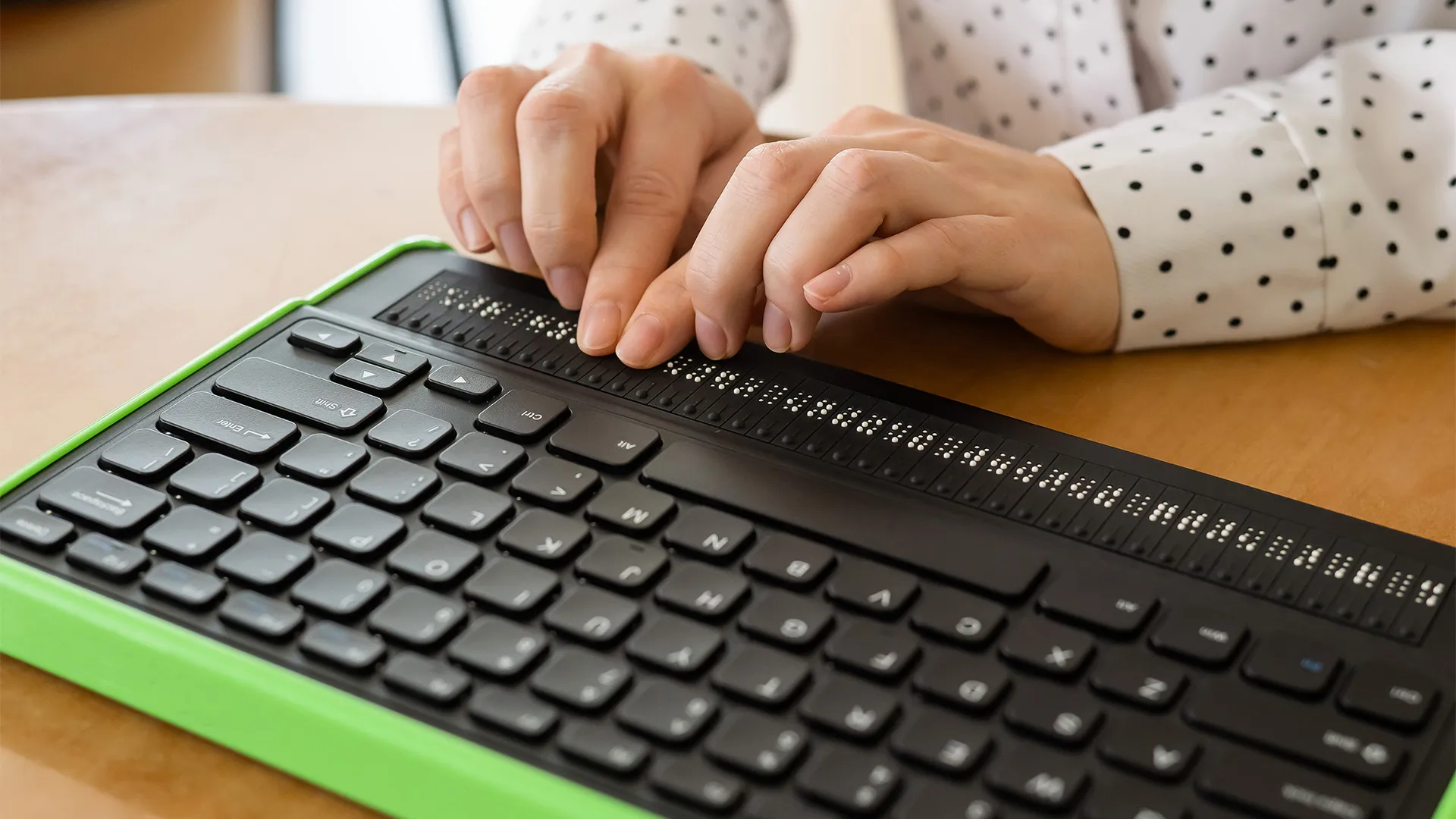 AdobeStock_506346394_CropSiteOS Des mains de femmes qui parcours un lecteur d'écran en braille.