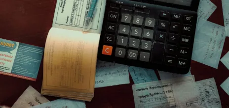 calculatrice et des factures éparpillées